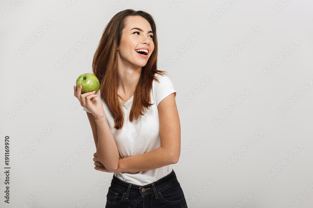 Portrait of a cheerful young woman holding green apple Portrait of a cheerful young woman holding green apple