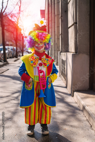 Little boy dressed as a clown.