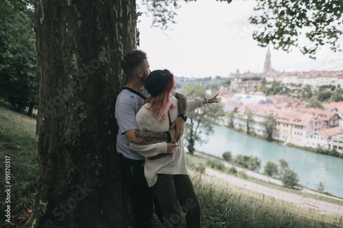 young couple in love hugging near big tree and looking at Bern cityscape © LIGHTFIELD STUDIOS