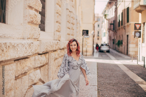 smiling elegant girl in glamorous grey dress walking in Verona © LIGHTFIELD STUDIOS