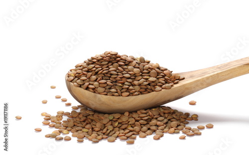 Pile of green lentils in wooden spoon isolated on white background