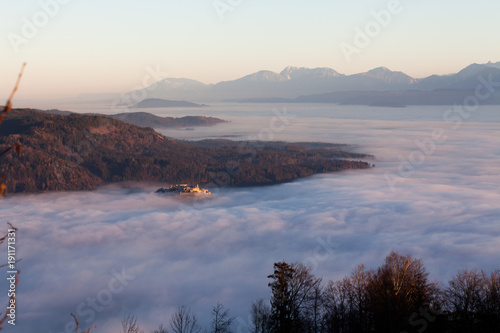 View of castle Landskron in Villach, Austria standing out of fog in all sourrounding valleys photo