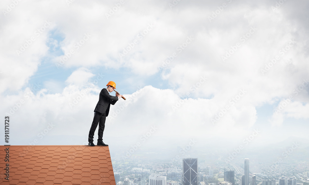 Engineer man standing on roof and looking in spyglass. Mixed media Engineer man standing on roof and looking in spyglass. Mixed media