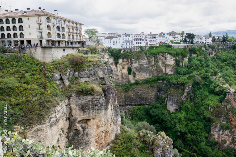 White houses sitting on the edge of a cliff in Ronda, Spain