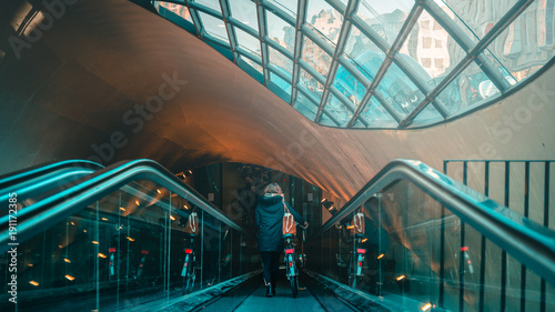Woman on an escalator with bike