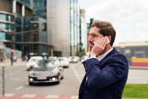 Businessman standing on a city street talking on his cellphone