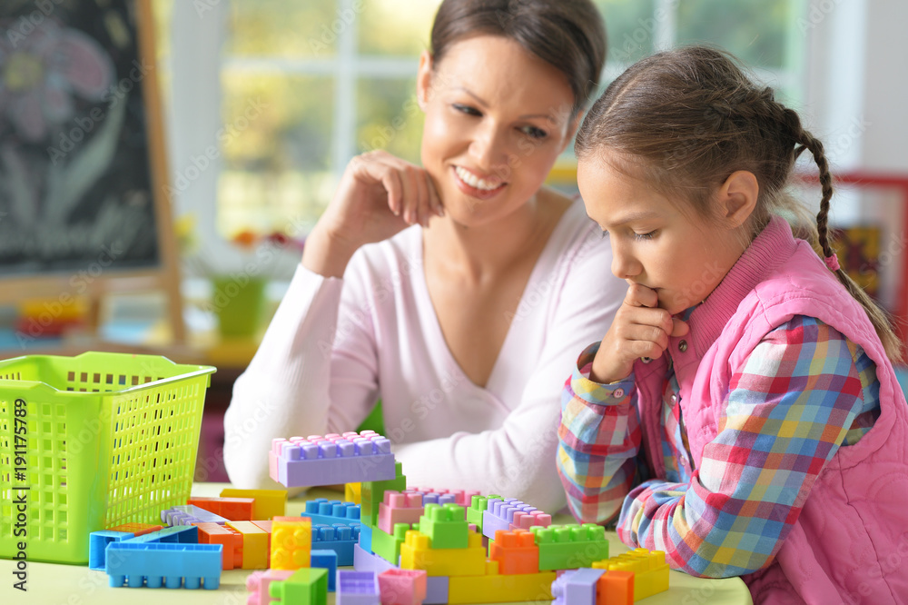 little girl and her mother playing with colorful plastic blocks little girl and her mother playing with colorful plastic blocks