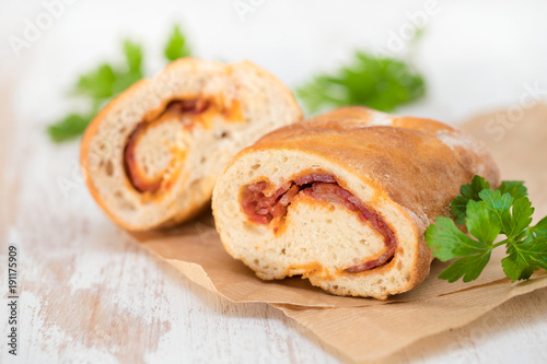 bread with smoked sausage on paper