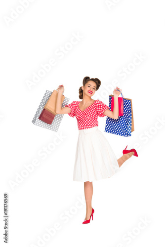 young woman in retro style clothing with shopping bags isolated on white