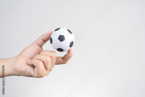 Hand holding small soccer ball or football