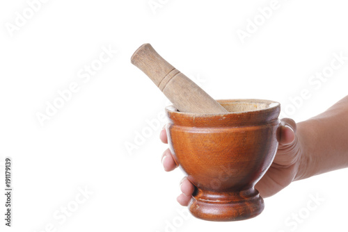 Hand holding wooden mortar and pestle made of wood