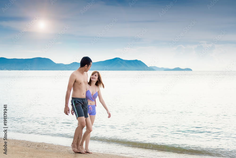 Young Couple walking romantic travel honeymoon on Beach