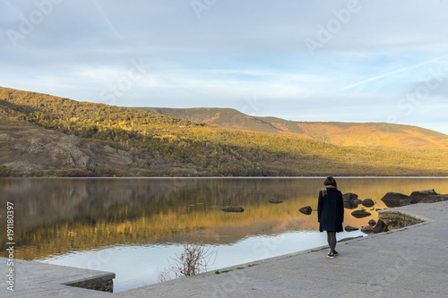 Sunset with woman on the edge of a glacier lake. Sanabria Lake. photo