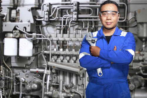 Portrait of Asian an mechanic engineer with machine background