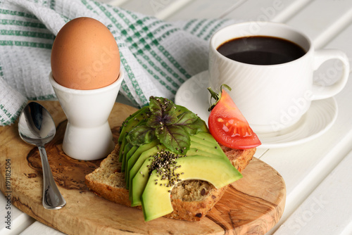 Sandwich with avocado and poached egg - healthy breakfast concept