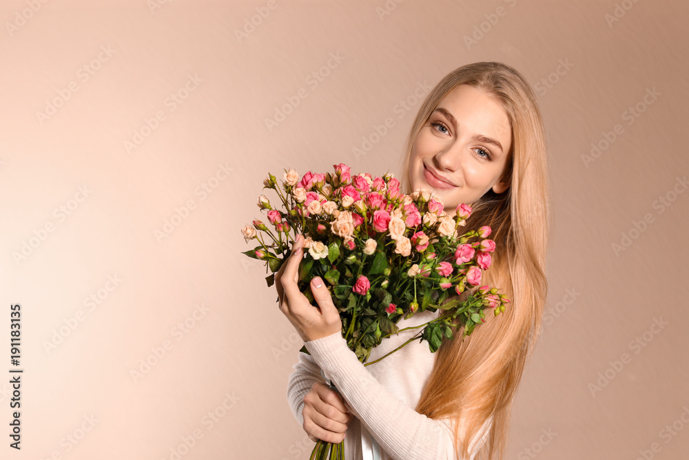 Beautiful young woman with bouquet of roses on color background