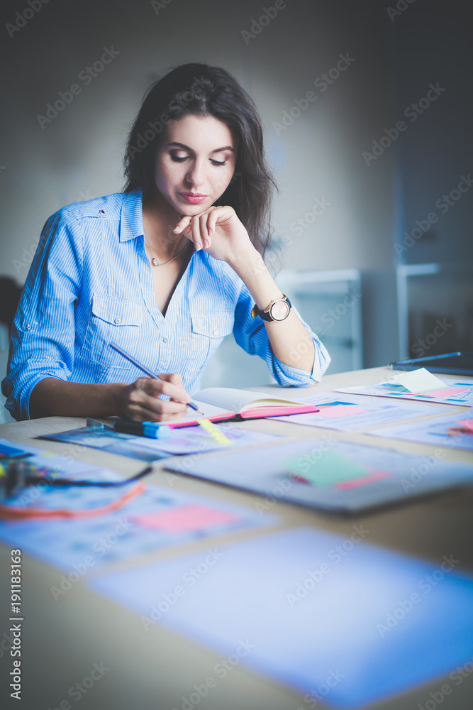 Fototapeta premium Young woman sitting at office table . Young woman.