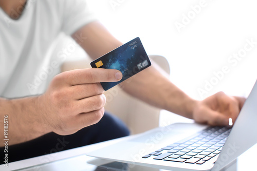 Man with credit card and laptop, closeup