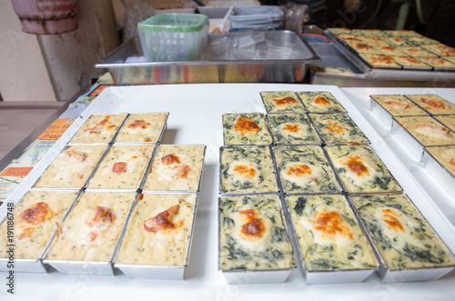 Baked spanish with cheese and baked cheese with bacon in tin coating packaing for sell at Wang Lang market, Bangkok, Thailand photo