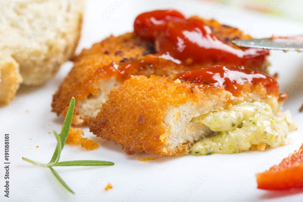 Chicken cordon Bleu on plate with tomato sauce or ketchup and bread Chicken cordon Bleu on plate with tomato sauce or ketchup and bread