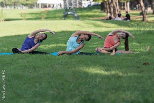 Family practicing yoga in the park outdoor. Concept of healthy lifestyle and relaxation..