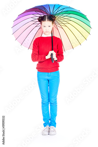 Portrait of cute Asian girl standing under open multicolored umbrella on white background