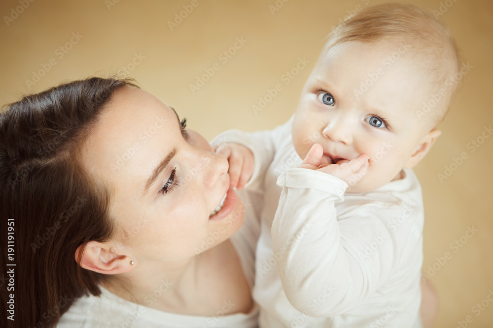 Mother looks at child with care love, baby on arms Mother looks at child with care love, baby on arms