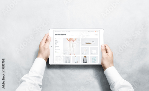Hands holding tablet with fashion webstore mock up on screen, isolated. Clothing web page interface mockup. Internet website online template on the device display.