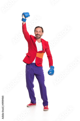 Male boxer in colorful clothes. Raising one hand and smiling.