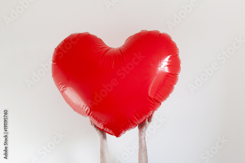 Hands holding a large inflatable heart shape photo