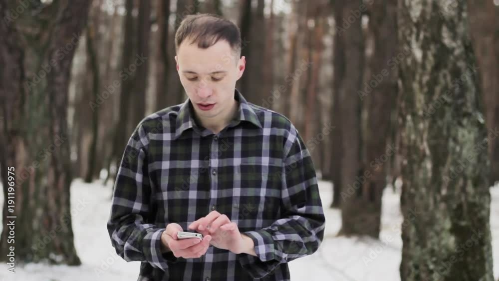 guy in the snow-covered cold forest with a mobile phone guy in the snow-covered cold forest with a mobile phone