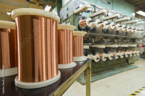 фотографія Standard copper wire enamel in a bobbin on the table, steel floor in the factory