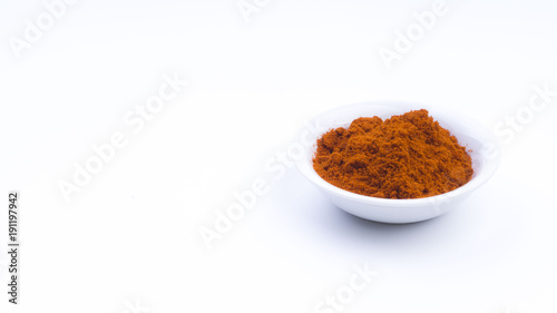Fototapeta Naklejka Na Ścianę i Meble -  Red Chilly Powder in a bowl on white background. Selective focus and crop fragment.