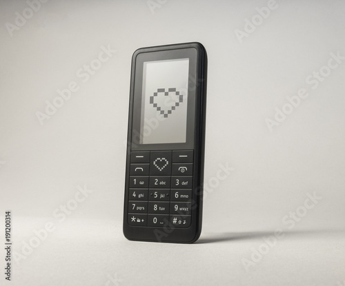 Mobile phone sending love heart. Portable communication device. Valentines day text message