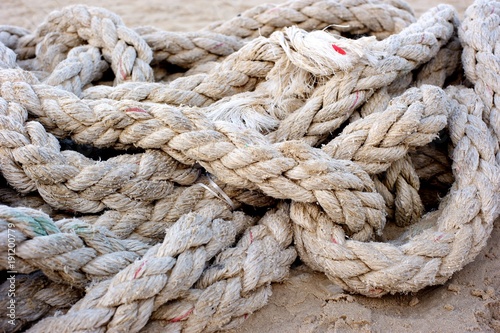 An old abandoned thick rope laying at the beach.