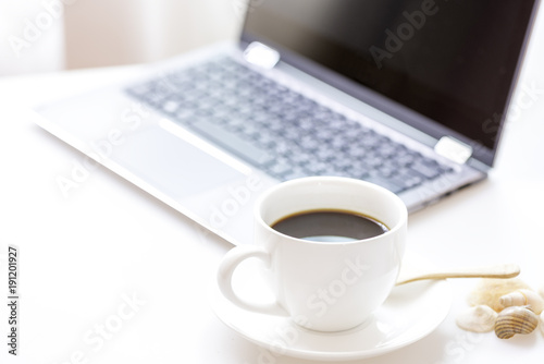 Cup of coffee and modern touch screen notebook.