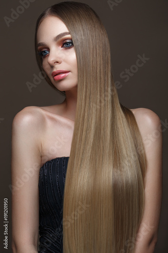 Beautiful blond girl with a perfectly smooth hair, classic make-up. Beauty face. Picture taken in the studio on a white background.
