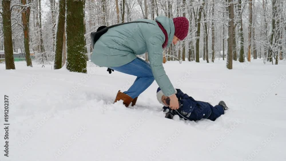 A mother and her baby boy playing outside in the snow A mother and her baby boy playing outside in the snow