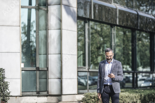 Businessman Typing on Cell Phone photo