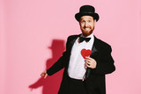 funny guy in tux and top hat holding a red heart, be my valentine