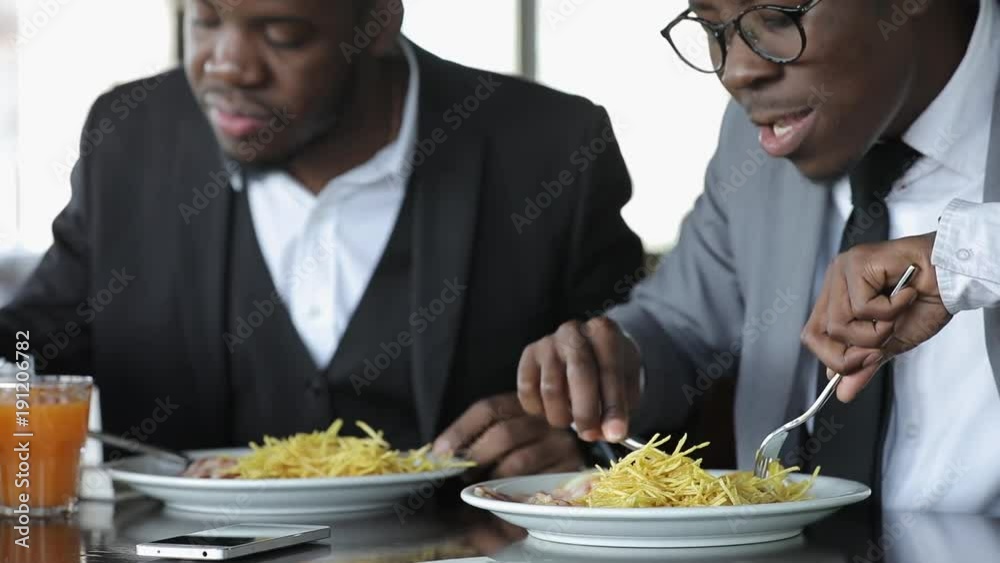 Business men eating harmful fast food. Dishes with fried potatoes. Business men eating harmful fast food. Dishes with fried potatoes.