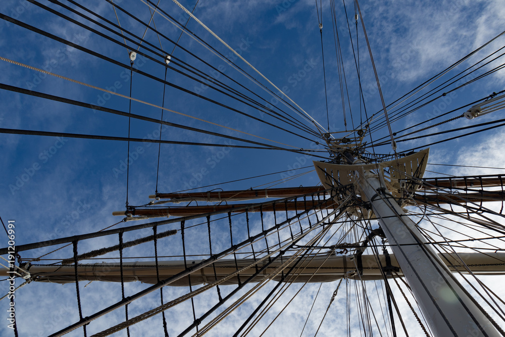 Obraz premium Sailboat Mast and ropes with cloudy blue sky in the background