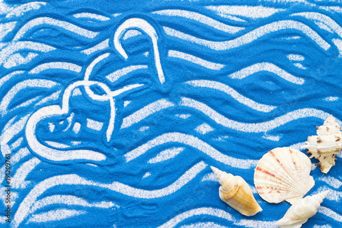 Hearts drawn on a colored blue sand and sea shells, travel, love, wedding concept background, top view, flat lay photo