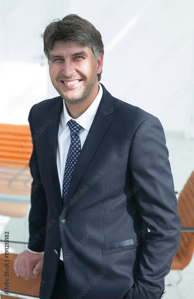 successful businessman standing by the desk.