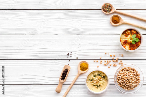 Cook chickpeas. Make hummus. Bowls with grains and ready meal near spices on white wooden background top view copy space