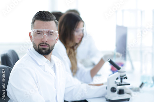microbiologist and his colleagues are sitting in a modern laboratory
