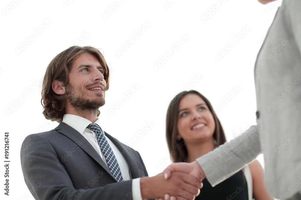 Businesspeople shaking hands against room with large window loo Businesspeople shaking hands against room with large window loo