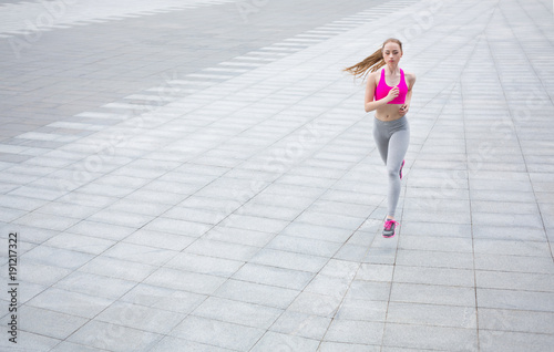 Young woman running in city copy space