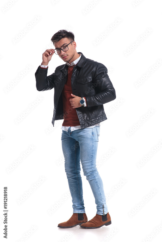 full body picture of a young man fixing his glasses full body picture of a young man fixing his glasses
