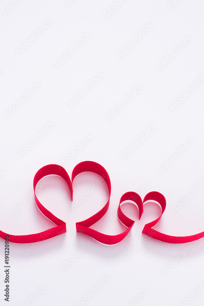 two red hearts from ribbon on white, valentines day concept